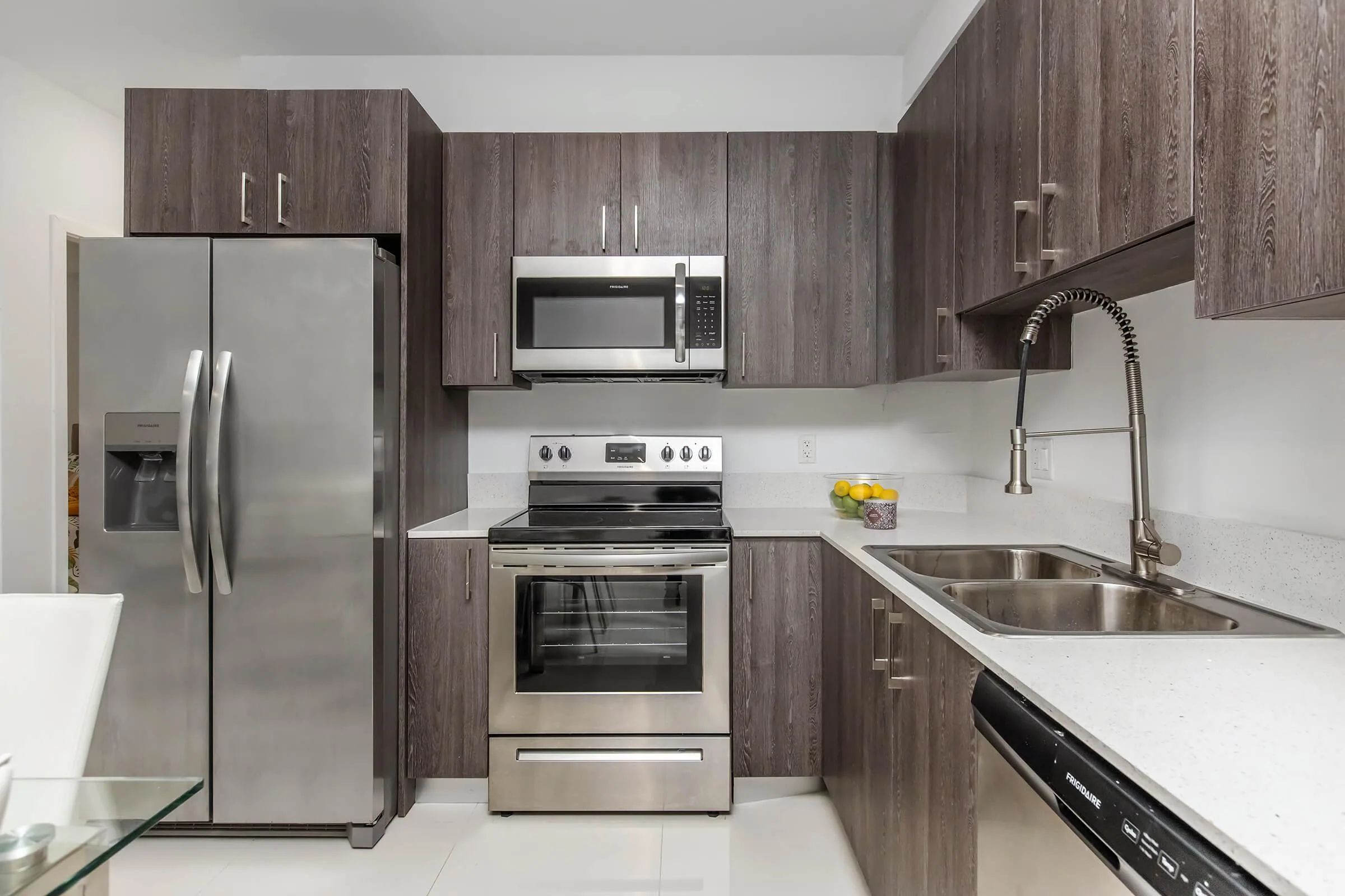 Kitchen with woodgrain cabinets and stainless appliances in Model D.